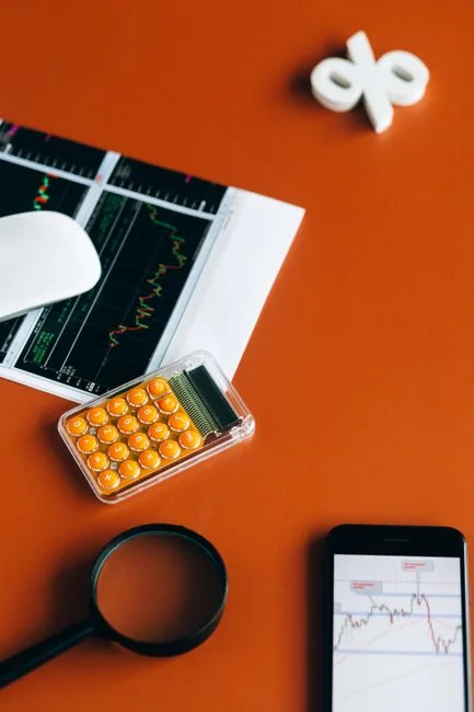 A modern workspace showing hands analyzing marketing data on a laptop and paper documents.